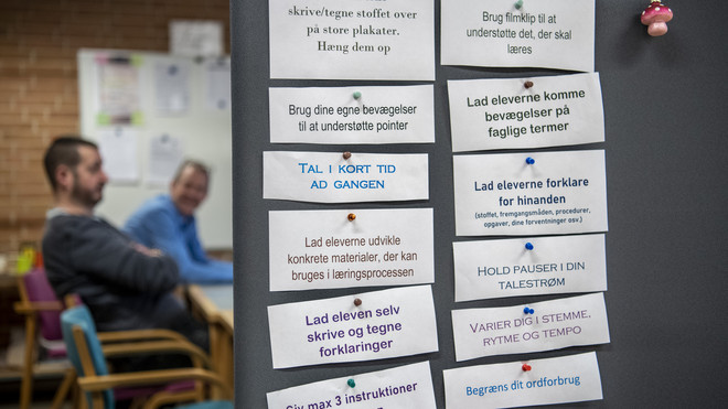 sedler med didaktiske råd hænger ved dør til lokale, hvor lærere snakker
