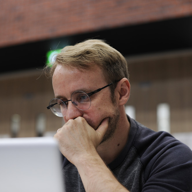 Tænkende mand sidder foran sin pc